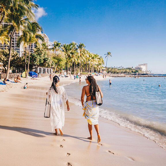 2 women walking along Waikiki beachfront
