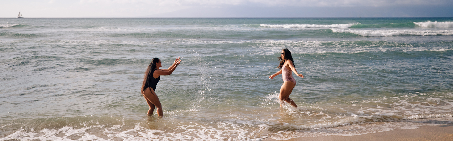 Twom women splashing on the beach