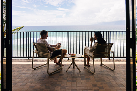 Couple having coffee on balcony with ocean view