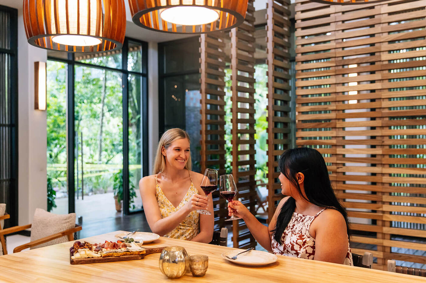2 women enjoying wine and food in restaurant