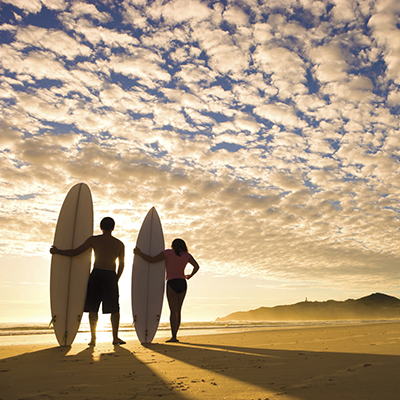 Couple with surfboards at sunset Waikiki Oahu Hawaii