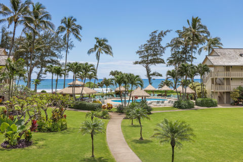 View of the lush grounds and the pool from the lanai of the One-Bedroom Ocean View room