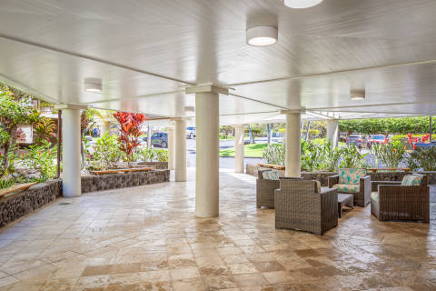 Resort exterior open air lobby walkway with chairs and tropical plants