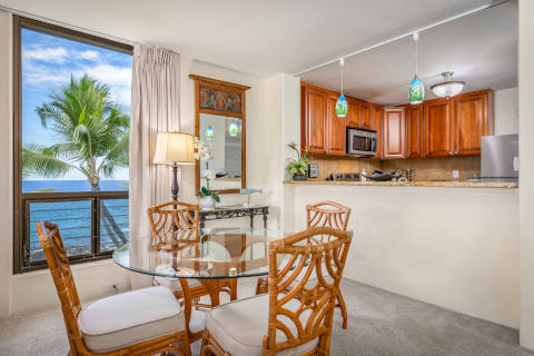 Two-Bedroom Oceanfront dining area with a circle glass table and four matching chairs and a window
