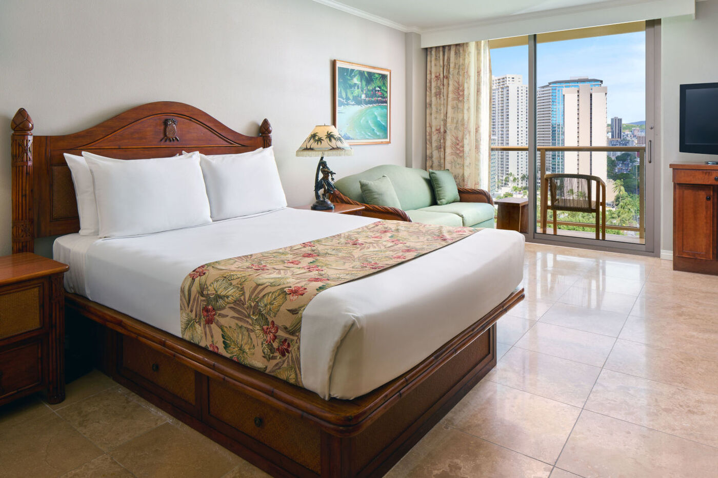 Luana Waikiki Hotel and Suites City View Room with a bed, a private balcony with a seating area the enjoy the views of the skyline.