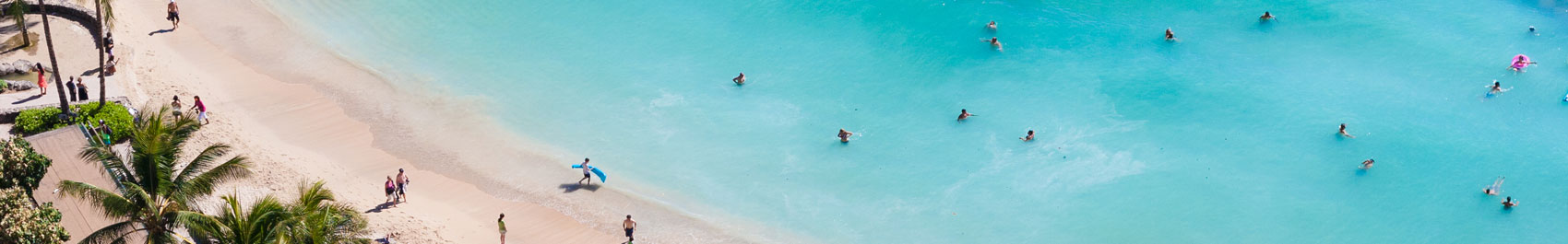Aerial view of sandy beach with people swimming