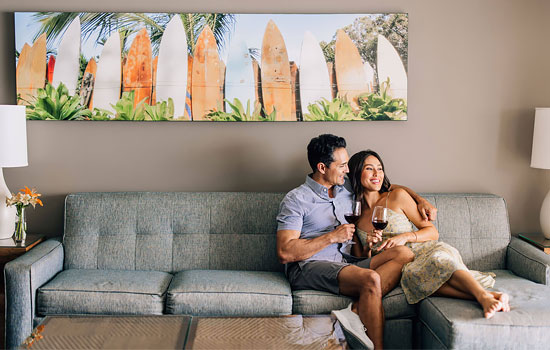 Couple relaxing on a large sofa in a vacation rental suite.