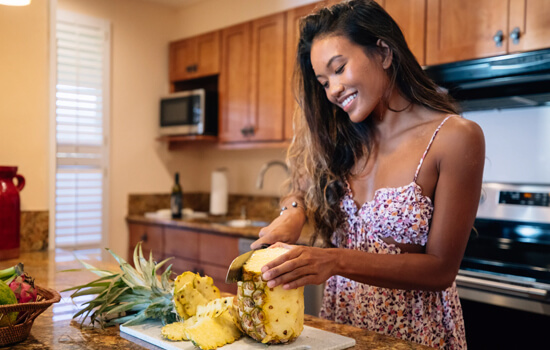 Woman cutting a pineable in the kitchen.
