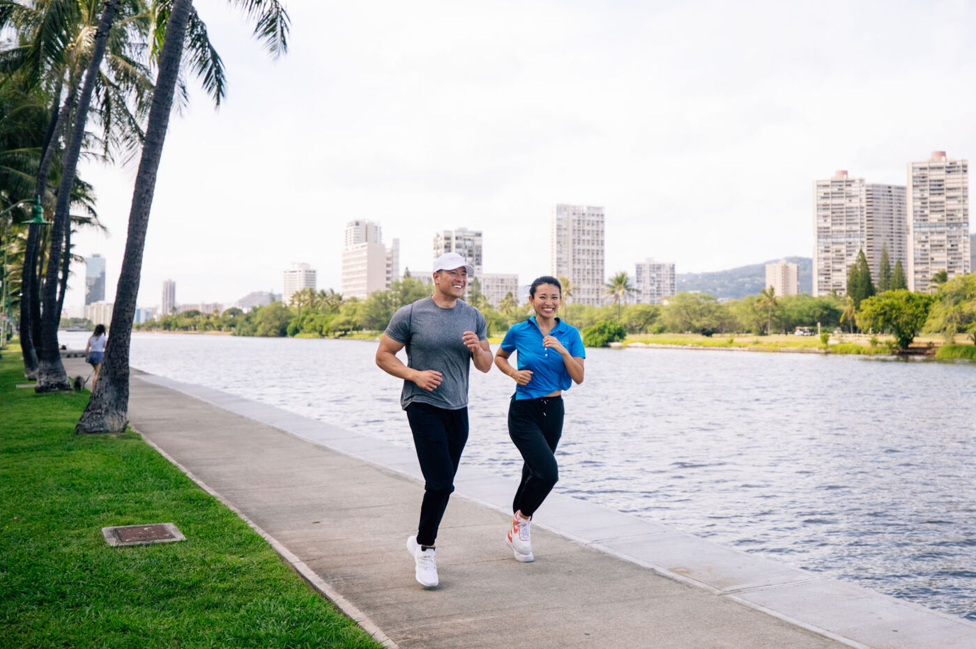 Couple jogging along the path next to the Ala Wai Canal near the Aqua Aloha Surf 