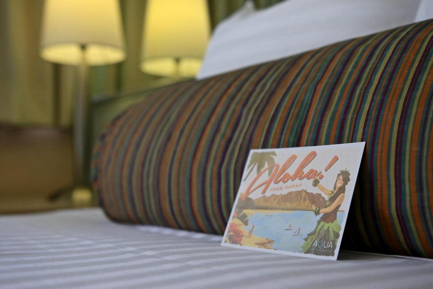 detail image of pillow on bed and postcard