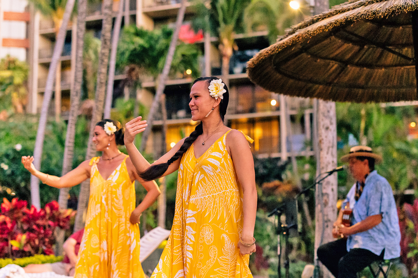 Two hula performancers with live music.