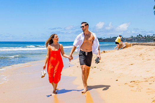 Husband and wife walking on the beach.