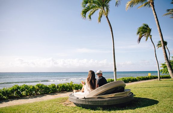 Oceanfront lawn with couple relaxing on lounger