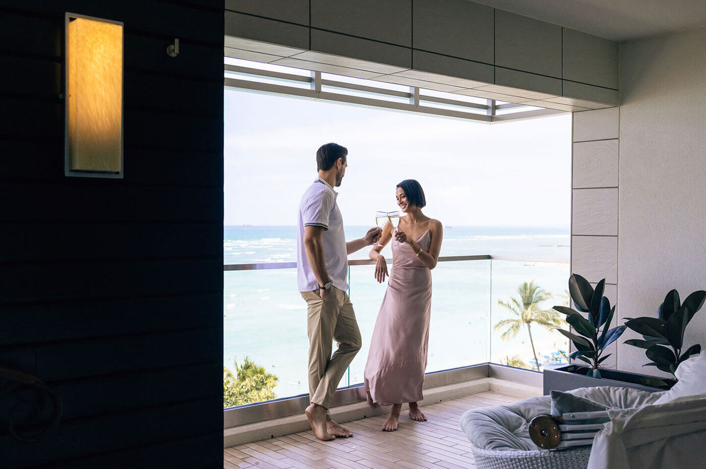 Couple drinking chamgane on balcony with ocean views