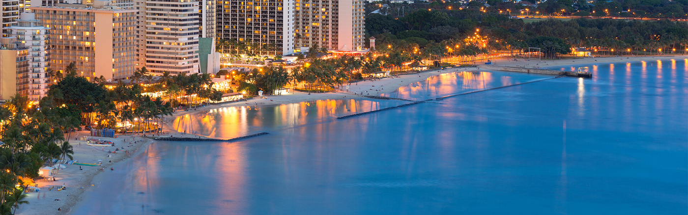 Overhead view of Waikiki shoreline and cityscape at dusk
