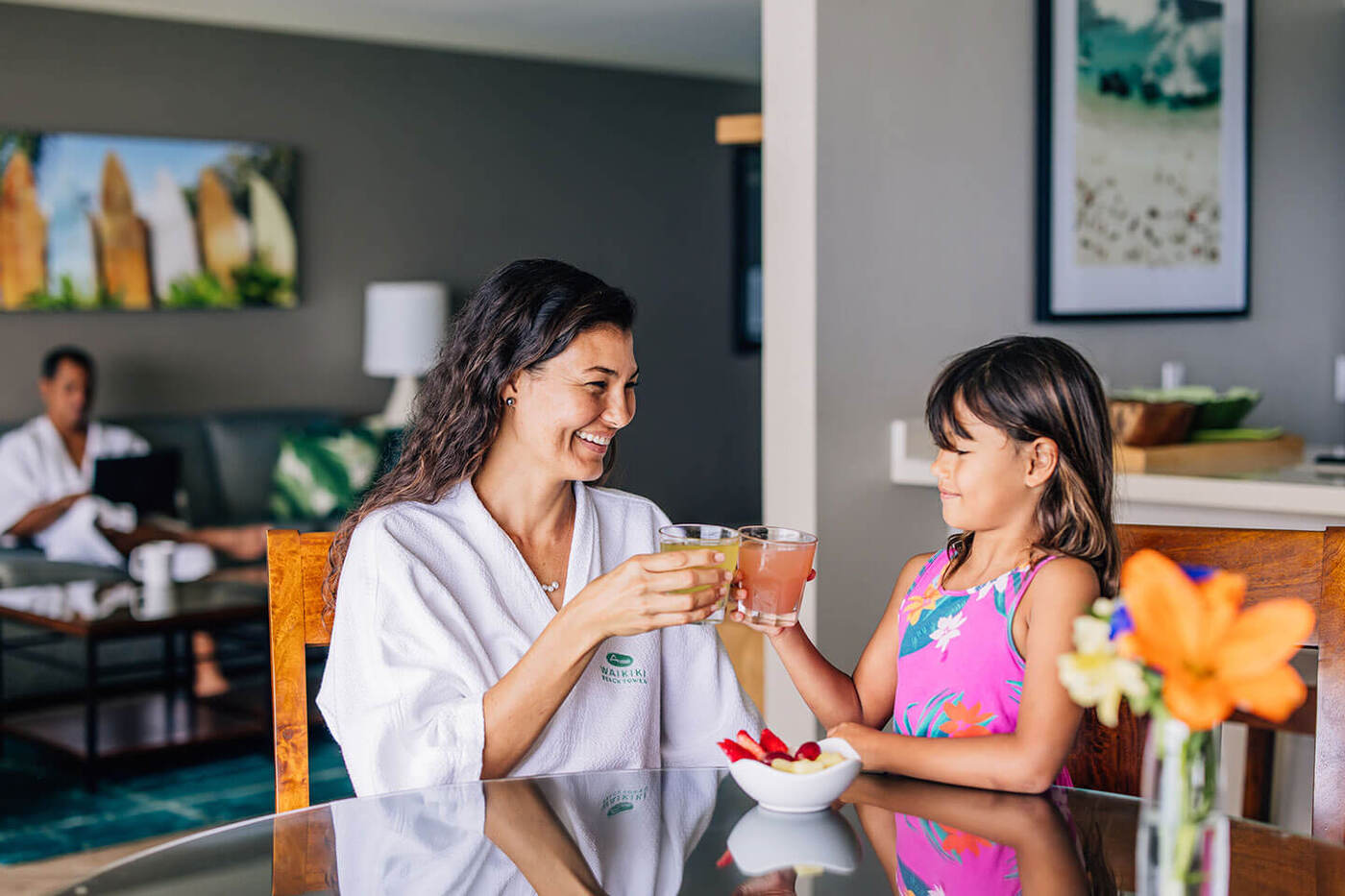 Mother and daughter having cups of juice at dining table