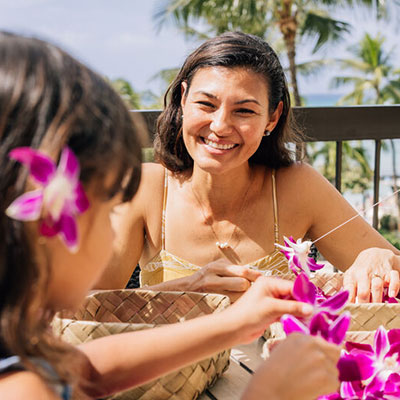 Woman and girl making a lei