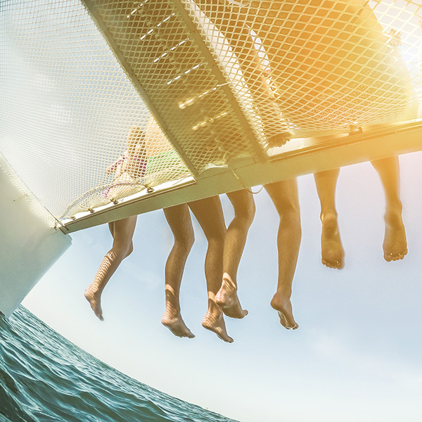 Legs dangling off the side of a catamaran in Waikiki beach Oahu
