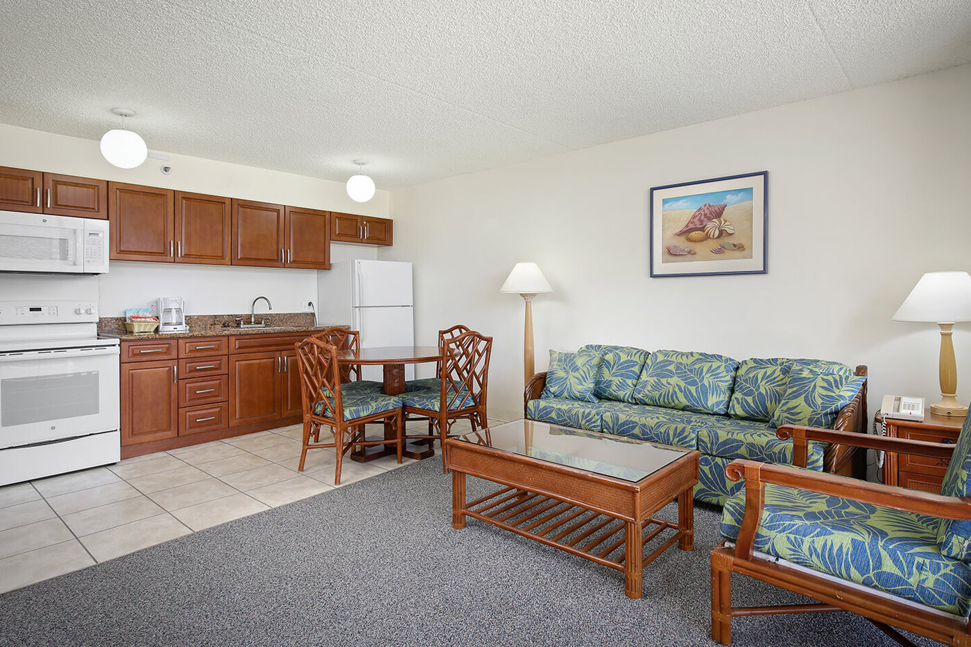 1-Bedroom Deluxe Mountain View living area with sofa, a fully equipped kitchen, and dining area.
