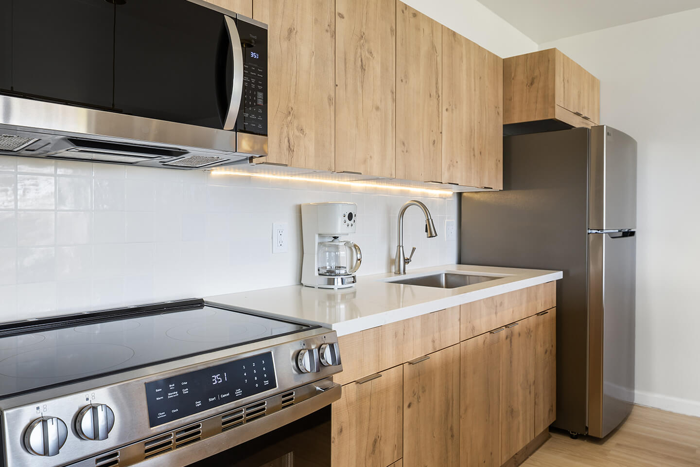Kitchen with new stove, microwave and refrigerator.