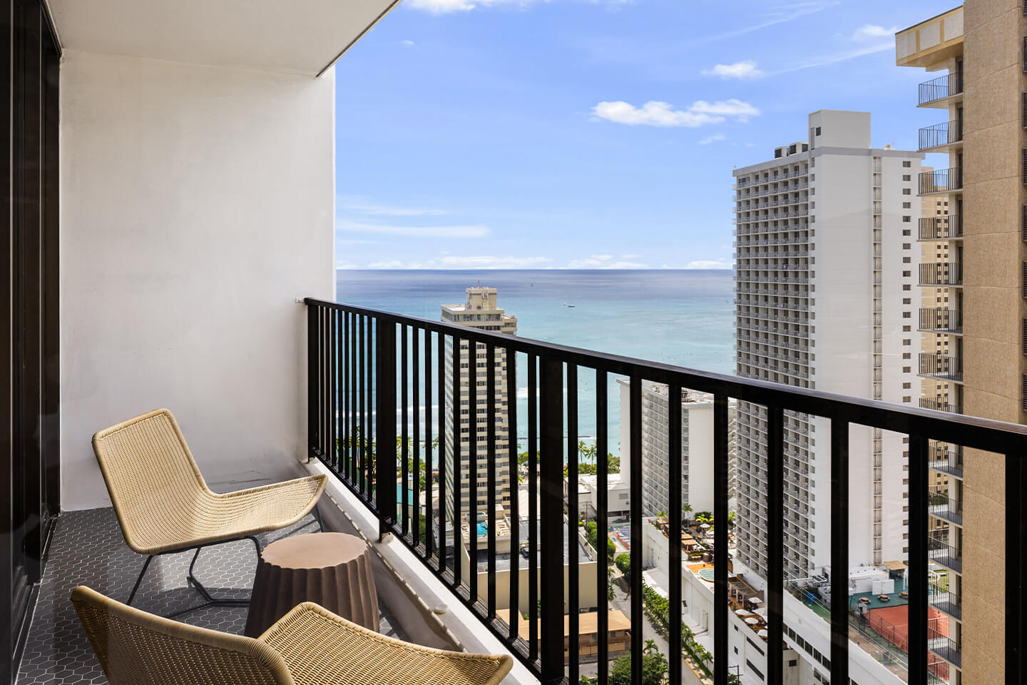 Balcony with chairs and view of ocean.