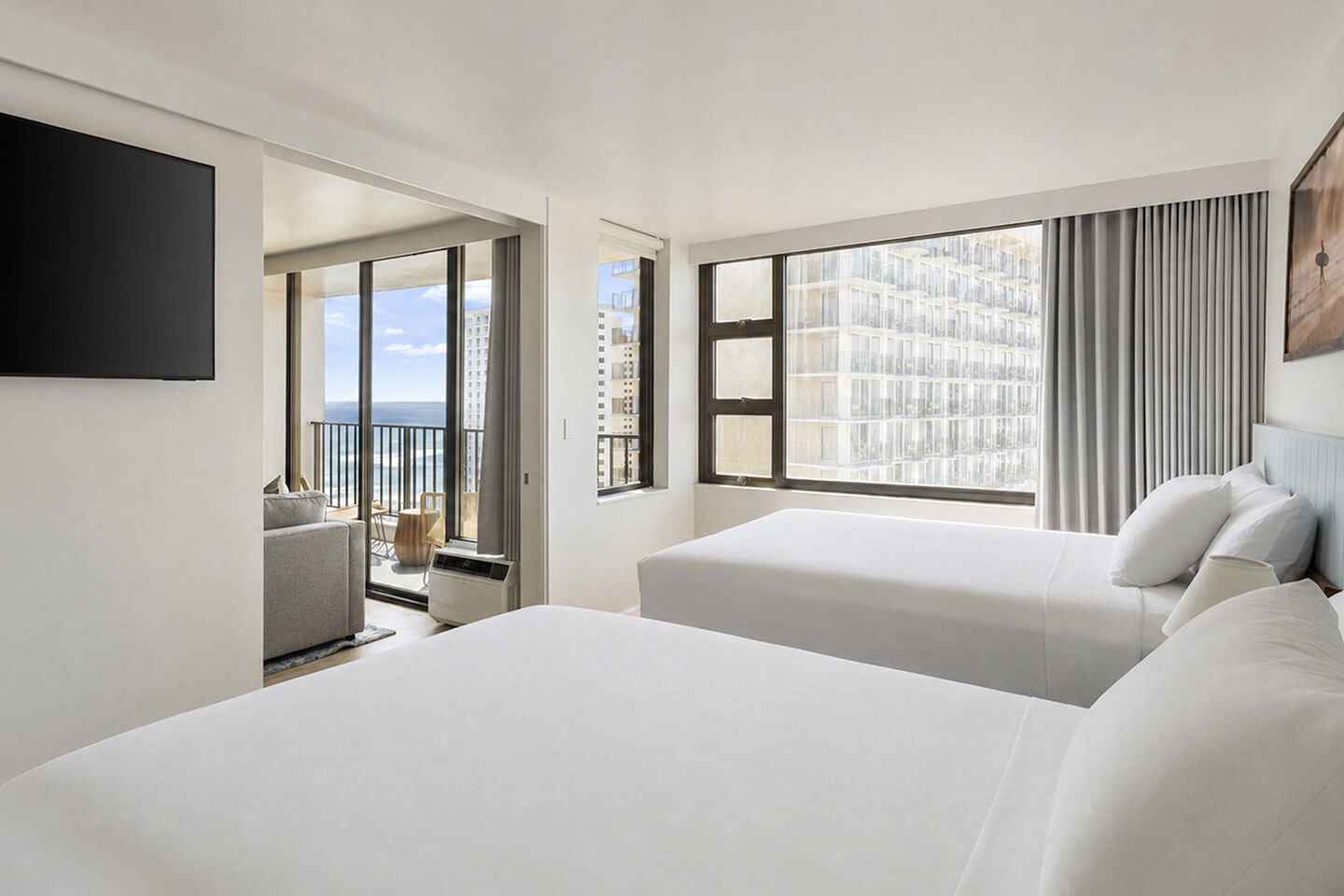 Bedroom with two queen beds and views of the city and ocean.