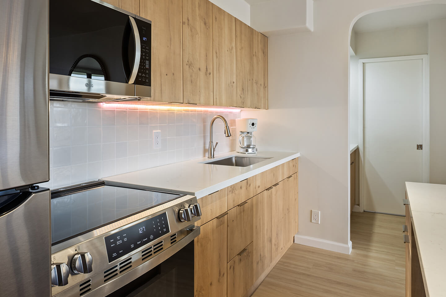 Kitchen with new stove, microwave and refrigerator.