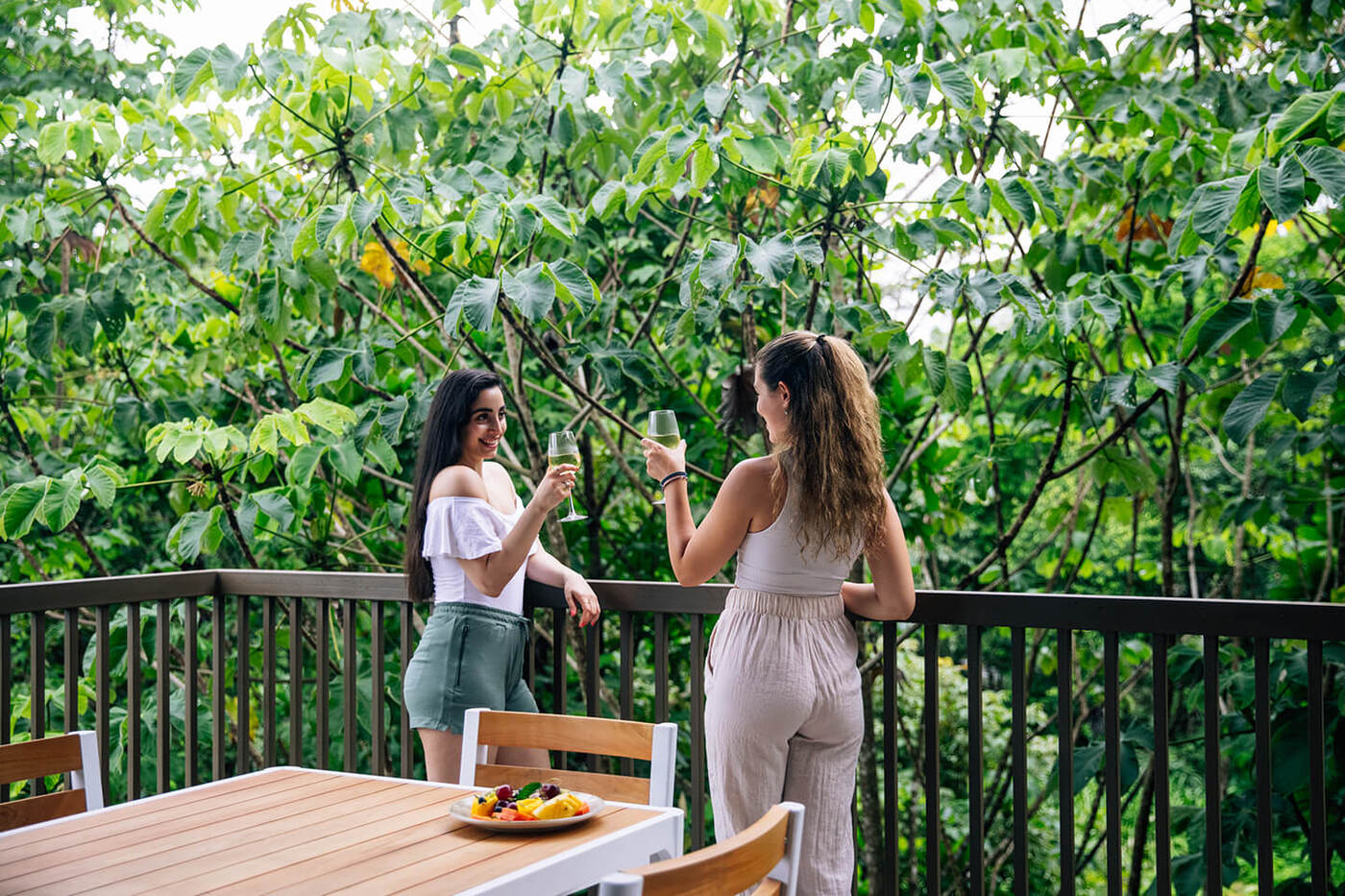 2 women enjoying glasses of wine on patio