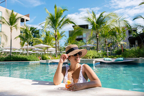WOman relaxing at pool with drink