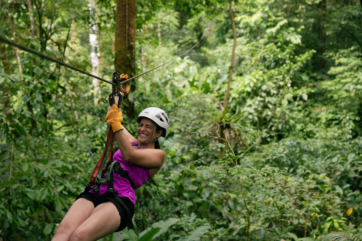 Woman ziplining in trees