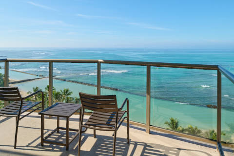 Oceanfront Deluxe Room balcony with seating to enjoy views of Waikiki Beach
