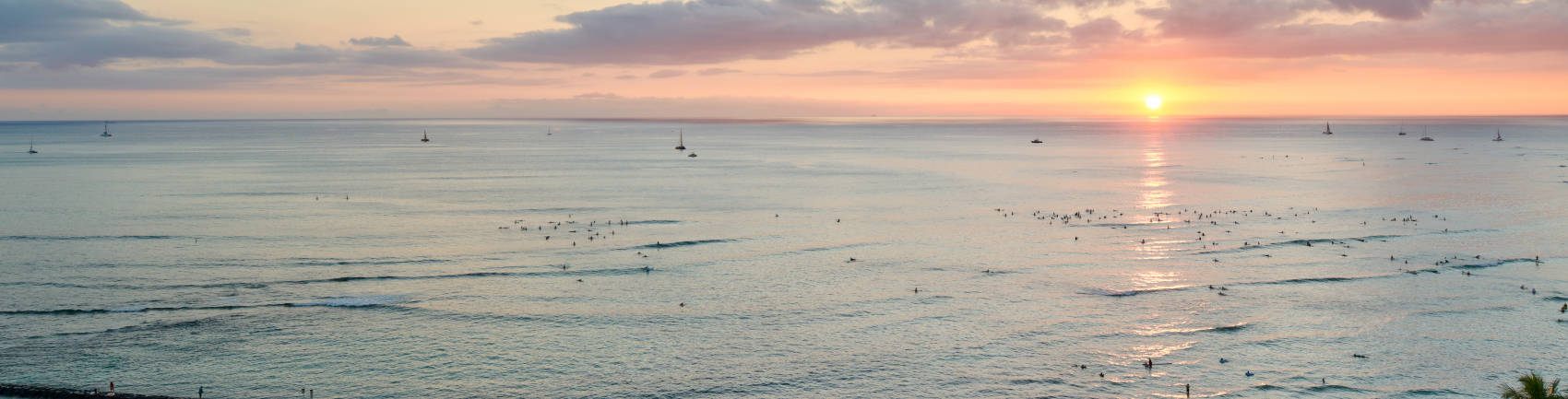 アストン・ワイキキ・サークル・ホテルから見た水平線に沈む夕日とワイキキビーチの美しい景色