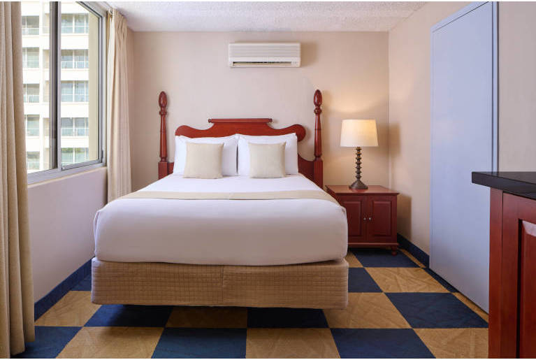 Moderate Hotel Room with one bed configuration with nightstand and lamp
