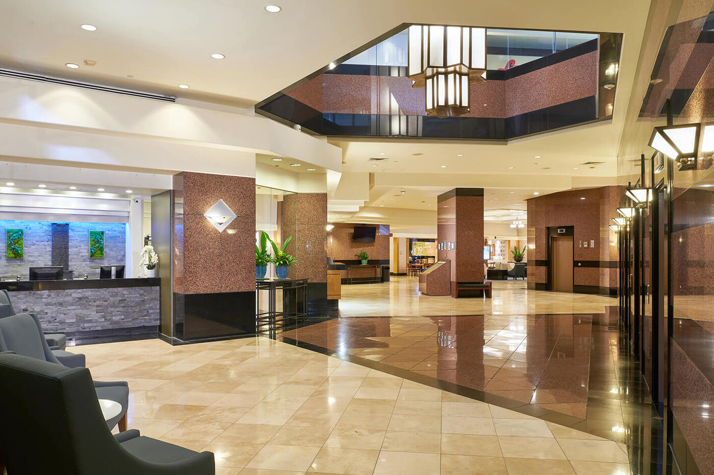 Lobby with front desk, seating, and elevators