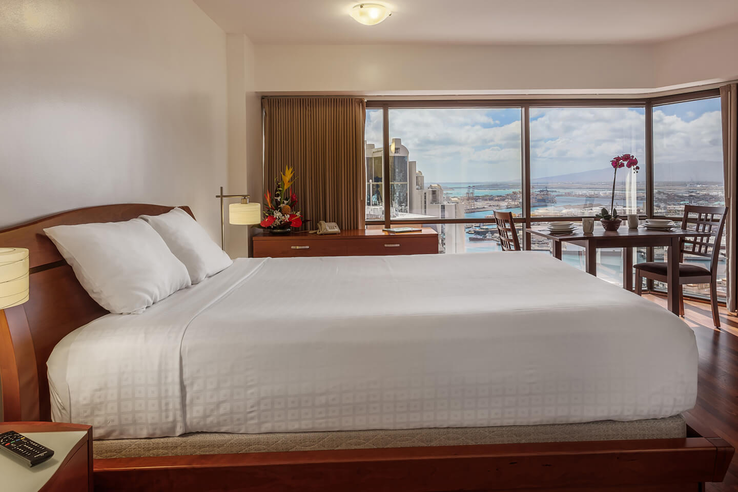 Bedding, seating area, and large picture window.