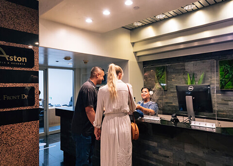 Couple checking in with front desk agent
