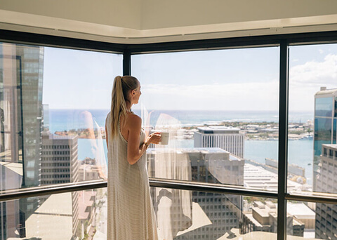 Woman looking at city from window