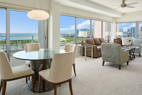 Suite dining table with chairs, seating area, and balcony with ocean views