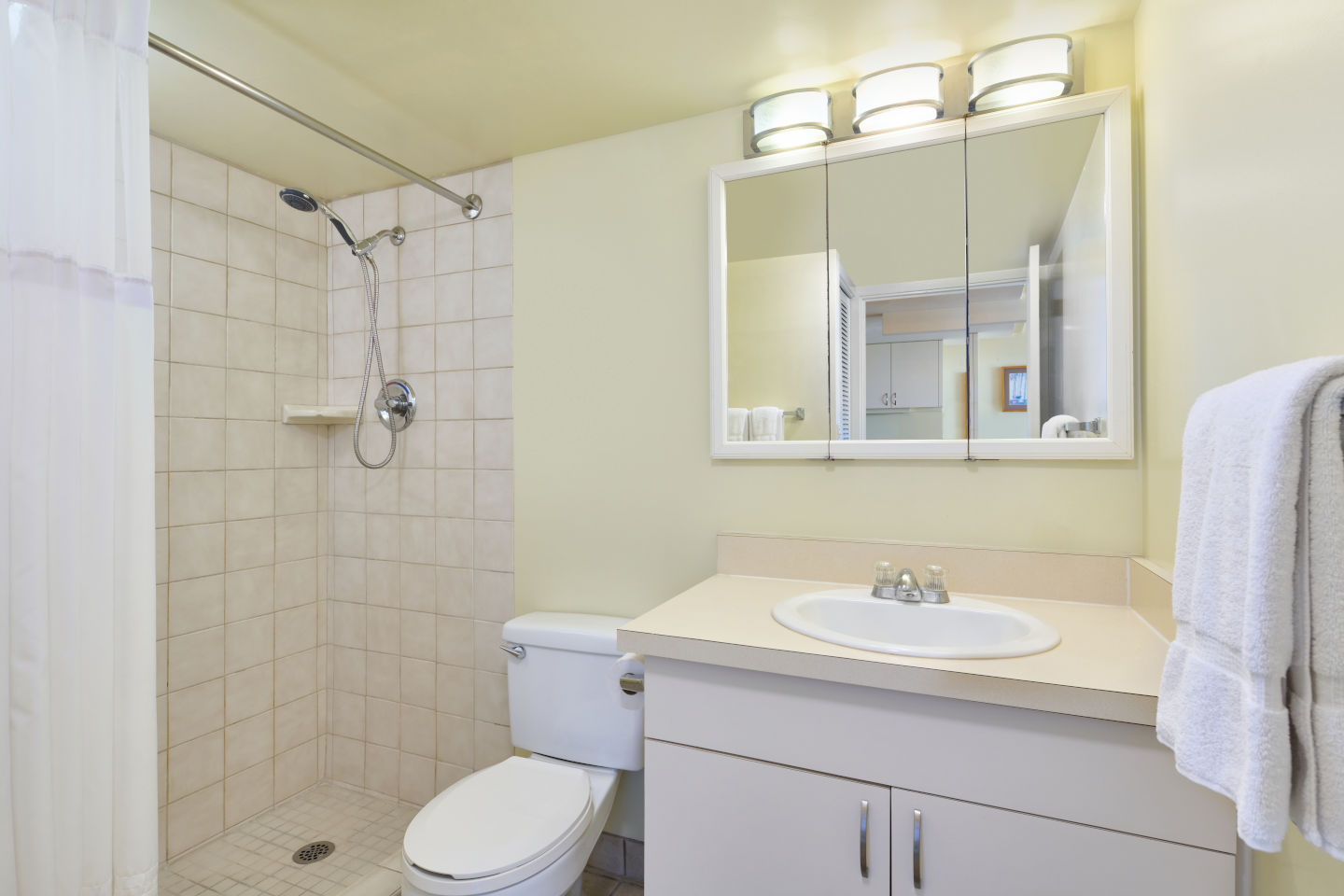 Bathroom with a lighted vanity mirror and a spacious walk-in shower in the Ilikai Lite Ocean View Jr Suite