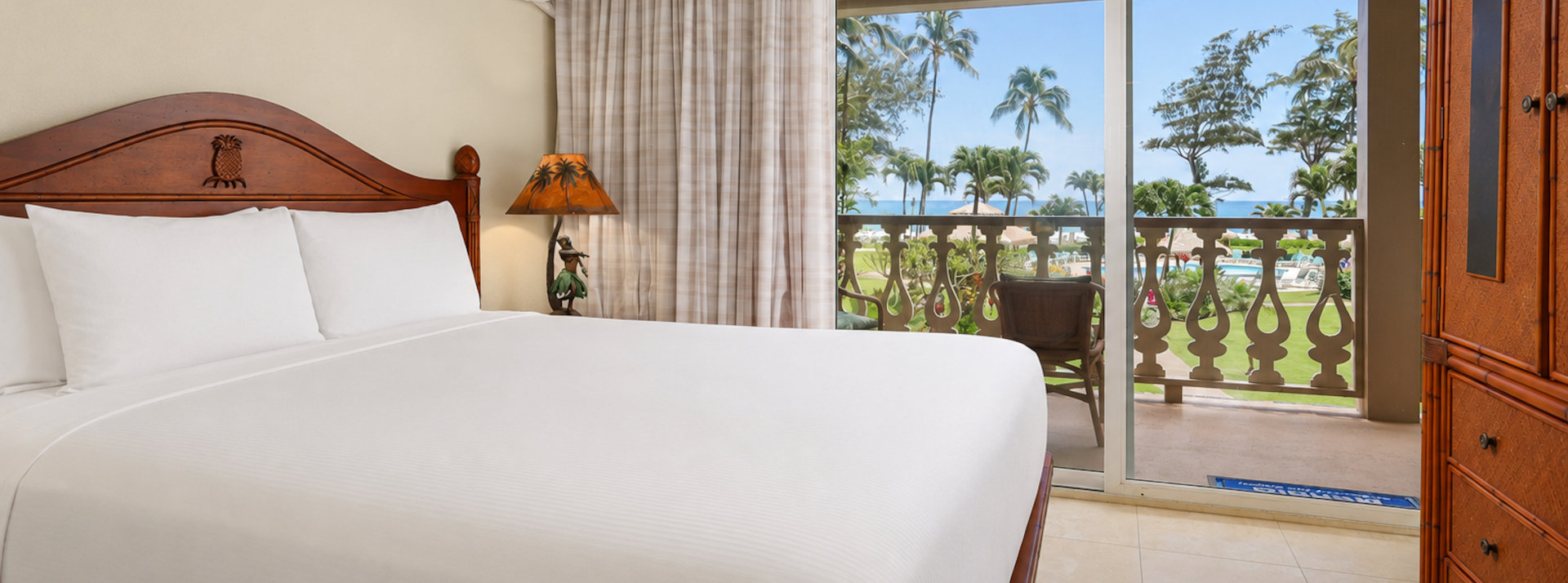 Room with bed, nightstands, lamps, couch, table, chairs, balcony, ocean view