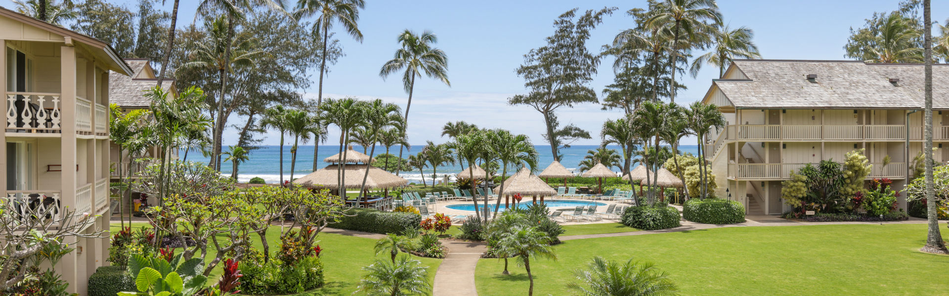 Aston Islander on the Beach lush grounds with palms trees, pool and access to the beach