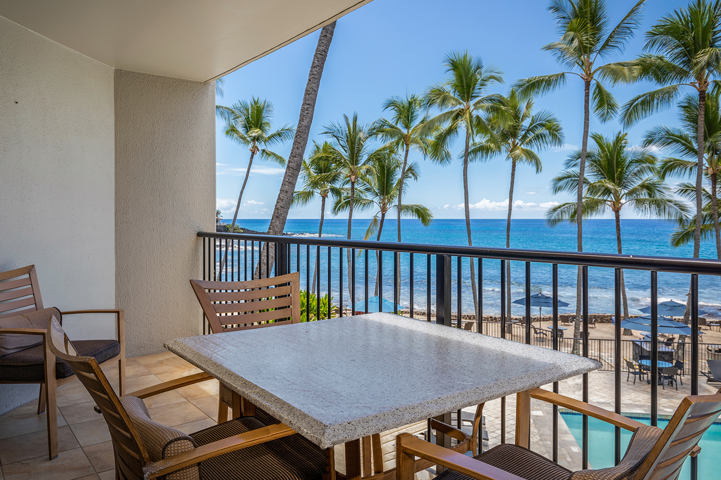 Balcony with seating and table overlooking the ocean.