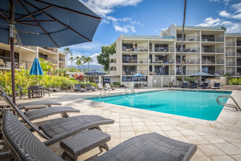 View of the pool from a lounge chair looking at the hotel and mountains in the background