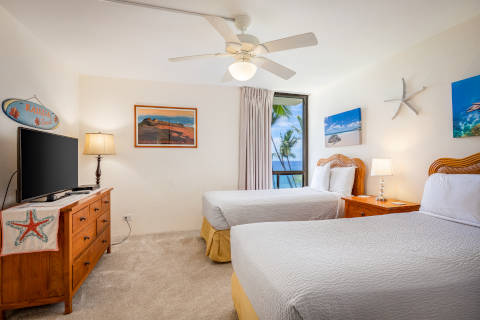 Two-Bedroom Oceanfront Second Bedroom with twin beds and a flat screen television, ceiling fan and corner window