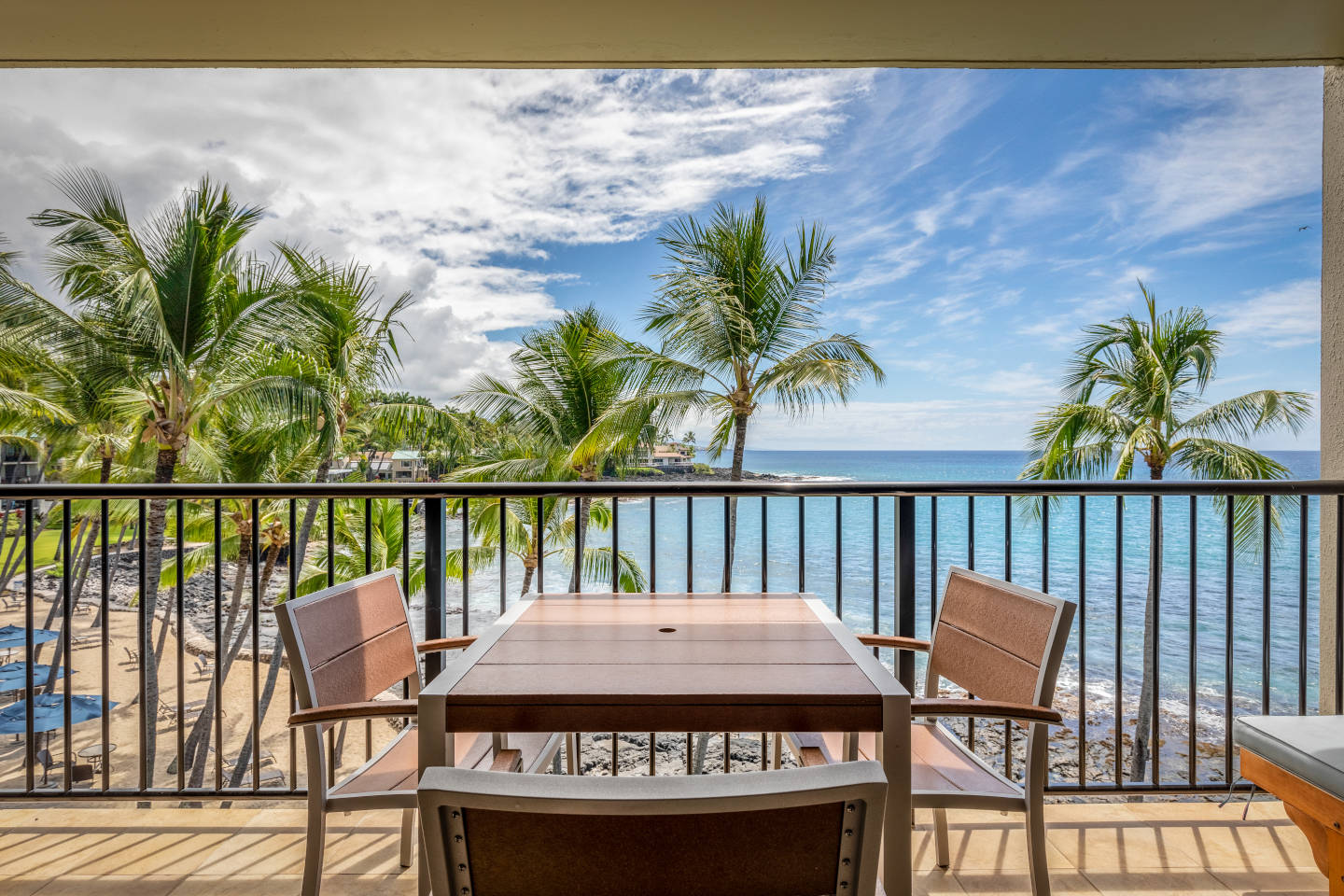 Balcony overlooking the beach with coconut trees and blue sky