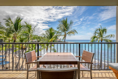 Two-Bedroom Oceanfront Lanai with outdoor table and chairs overlooking the beach