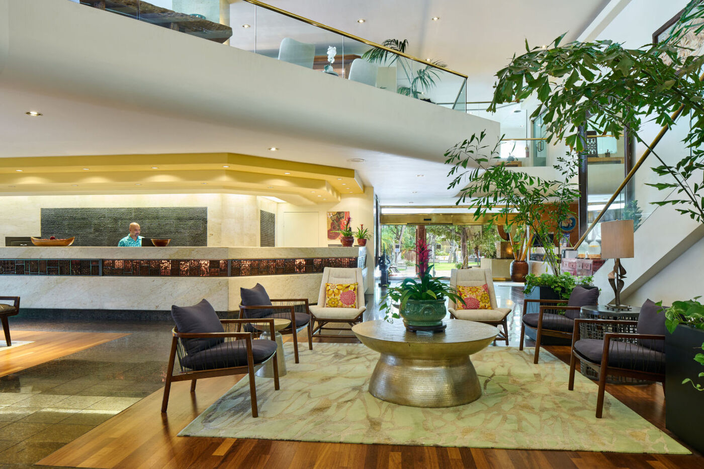 Lobby and front desk at the Luana Waikiki Hotel with comfortable seating area and tropical plants