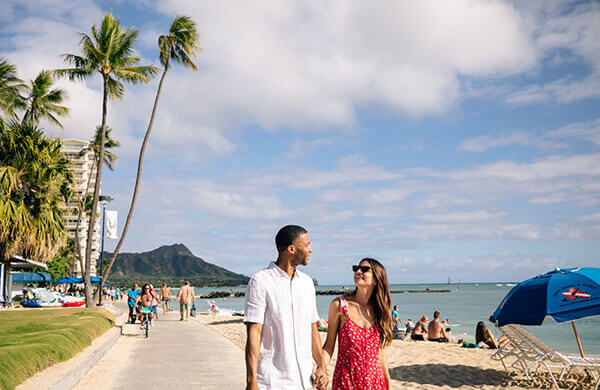 Couple walking along beach in Waikiki