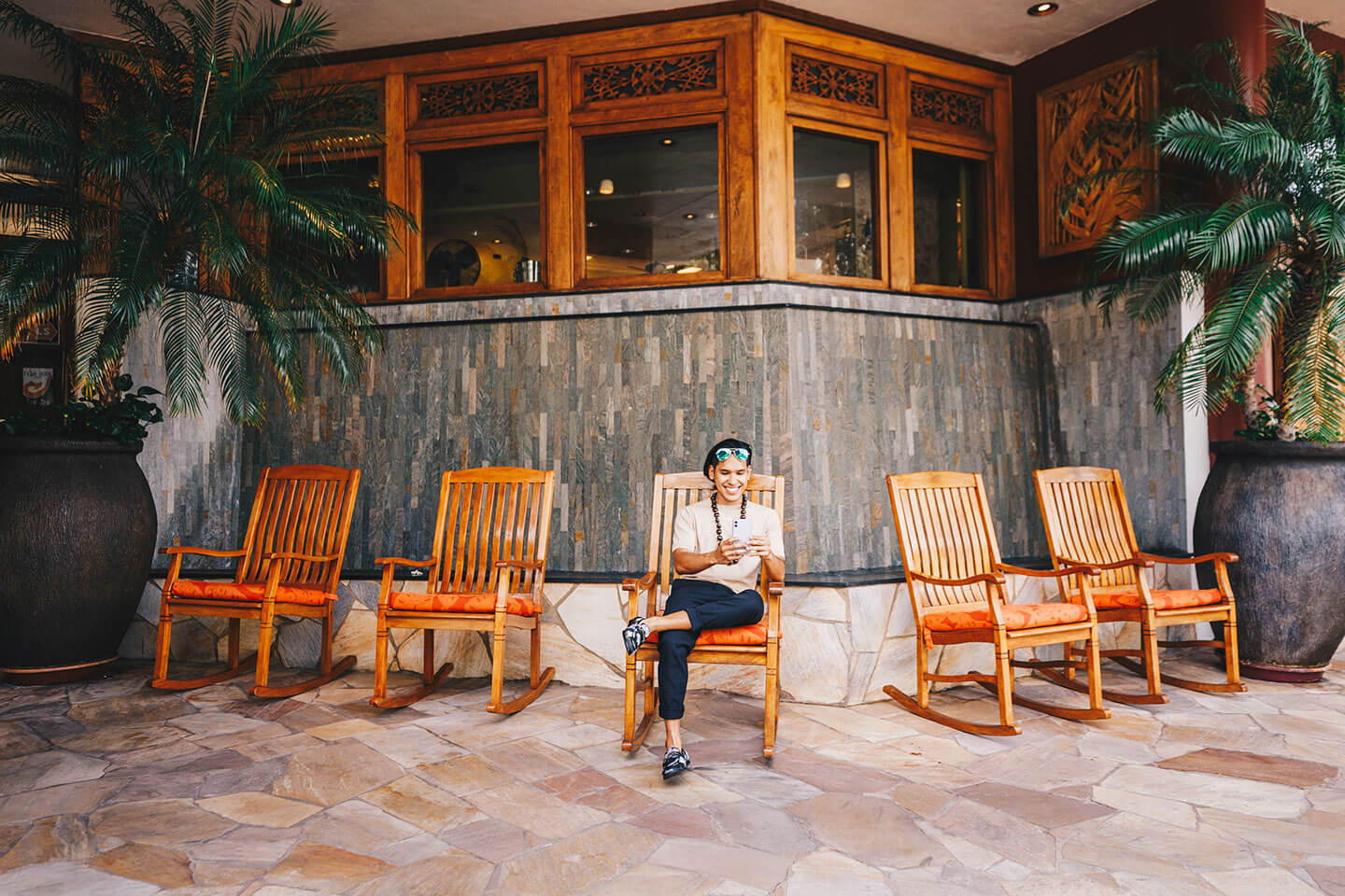Man relaxing on rocking chair in hotel porte cochere