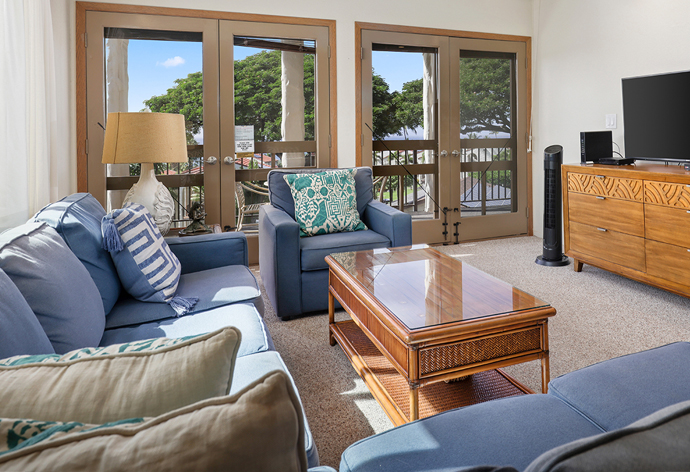 Living room with couch, coffee table, lamps, TV, balcony